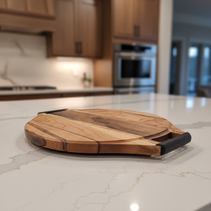 A round wooden cutting board with a natural wood grain pattern and a Wenge handle, resting on a white metal stand against a white fabric background.