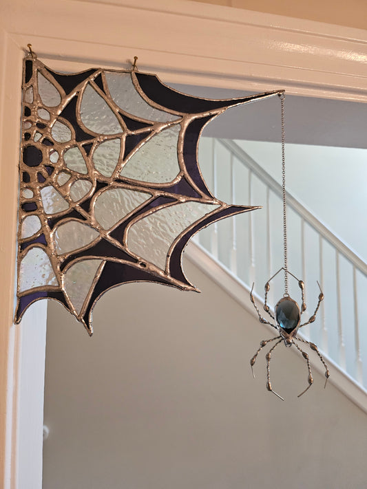 The Amethyst Web: Tiffany-style stained glass spider web suncatcher in amethyst and opalescent glass with a dangling glass-gem spider