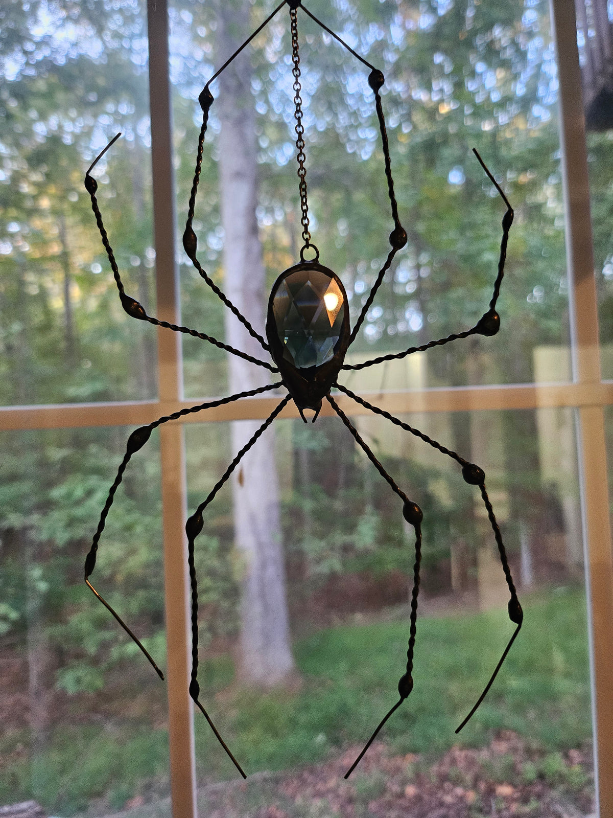 The Midnight Weaver: Tiffany-style spider suncatcher with a copper-foiled black glass prism and hand-twisted black patina legs